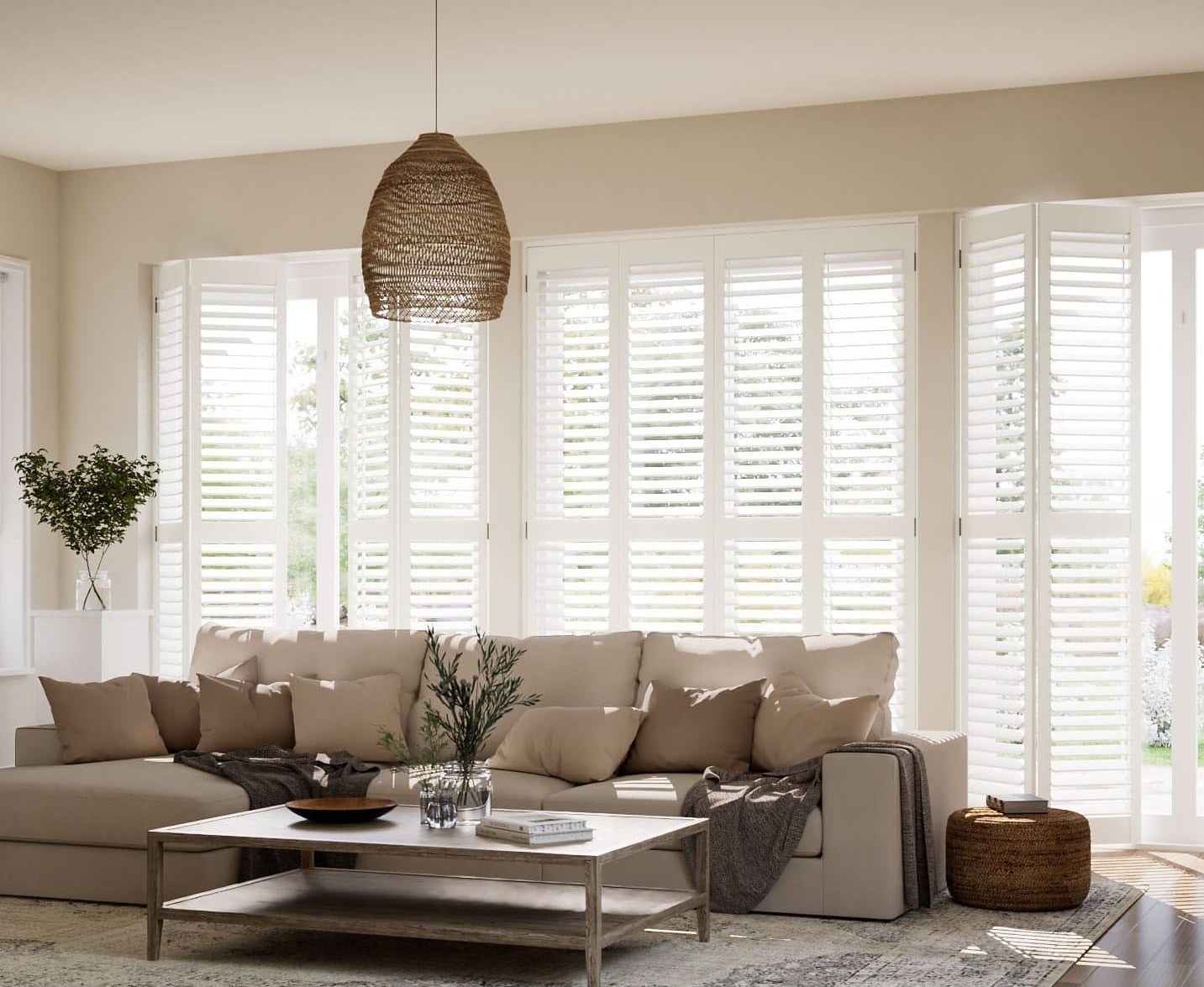 Full-height white plantation shutters across a wide living room window, louvres angled to lift daylight over the seating.